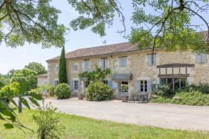 una gran casa de piedra con vistas al exterior en Logis Hôtel La Ferme de Flaran, en Maignaut