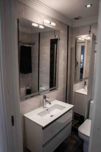 a bathroom with a sink and a toilet and a mirror at La bona vida Vitoria in Arriaga