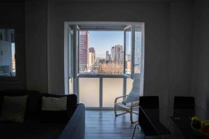 a living room with a view of a city from a window at La bona vida Vitoria in Arriaga