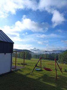 a swing set in a yard next to a house at Maraśka Holiday House in Kamienna Góra