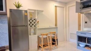 a kitchen with a stainless steel refrigerator and two chairs at B507-top Floor Pool View 1 Br At Ao Nang Beach in Ao Nang Beach