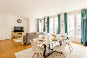 een woonkamer met een tafel en stoelen bij Spacious, Central & Historic Getaway - 5 Star Location in Parijs