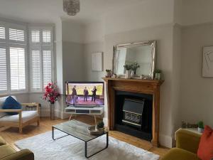 a living room with a fireplace and a mirror at Sleep up to 14 - Doncaster central in Doncaster