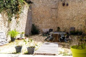 a patio with a table and chairs and a brick wall at la Perle Rare - Centre-Ville in Sète
