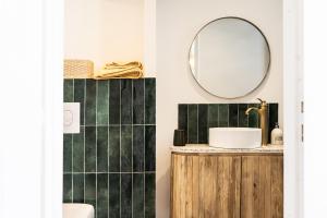 uma casa de banho com um lavatório e um espelho em Le grand Arth&M Clermont Ferrand em Clermont-Ferrand