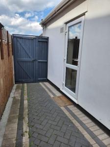a white house with a door and a fence at Beautiful private en-suite room with its own entry in Bexleyheath