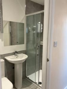 a bathroom with a shower and a sink and a toilet at Beautiful private en-suite room with its own entry in Bexleyheath
