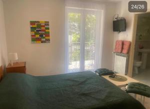 Un dormitorio con una cama verde y una ventana en Villa Amari, en Brela
