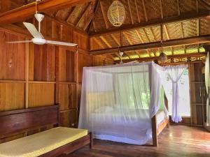 Habitación con cama y ventilador de techo. en Rambai Tree Jungle Lodges en Bukit Lawang