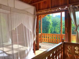 a screened in porch with a view of the forest at Rambai Tree Jungle Lodges in Bukit Lawang
