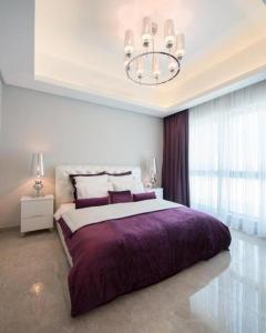 a bedroom with a large bed and a chandelier at Seef manzil in Seef