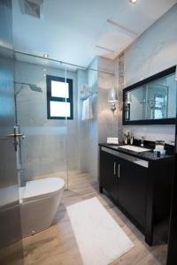 a bathroom with a toilet and a glass shower at Seef manzil in Seef