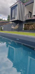 a house and a swimming pool with a hammock next to a house at Bicycle House in Felgueiras