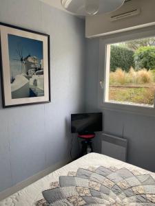 1 dormitorio con cama, ventana y TV en Appartement 3 pièces de 52 m2 face au port du Crouesty avec terrasse de 18 m2, en Arzon