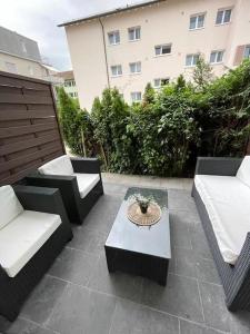 a patio with couches and a table and a building at Airport City Zürich in Opfikon