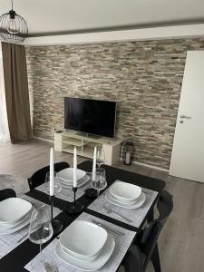 a dining room with a table with chairs and a television at Airport City Zürich in Opfikon