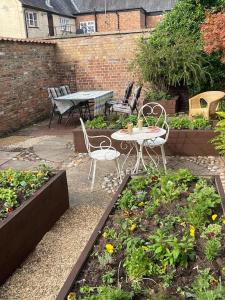 a patio with a table and chairs in a garden at Centre of town House 3 Bedrooms Sleeps 5 and Infant Free Onsite Parking 2 Cars in Kings Lynn
