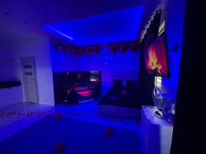 ein Wohnzimmer mit blauer Decke und einem Fernseher in der Unterkunft MP Apartament Białystok Jacuzzi in Białystok