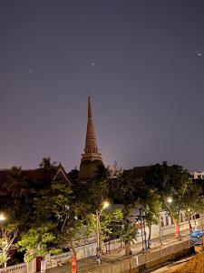 曼谷的住宿－Suraya Bangkok，一座高大的建筑,远处有陡峭的树木