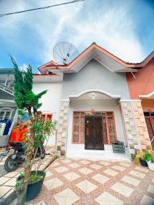 a house with a motorcycle parked in front of it at VILLA BUKIT MAS BERASTAGI DEPAN MIKIE FUNLAND in Berastagi