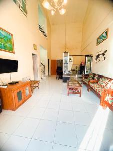 a large living room with couches and a flat screen tv at VILLA BUKIT MAS BERASTAGI DEPAN MIKIE FUNLAND in Berastagi