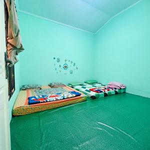 2 camas en una habitación con paredes azules en VILLA BUKIT MAS BERASTAGI DEPAN MIKIE FUNLAND en Berastagi