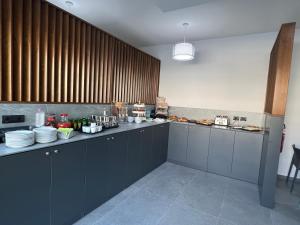 a kitchen with gray cabinets and a counter with plates at Hotel Paradiso in Comacchio