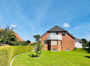 una gran casa de ladrillo con un patio verde en Fewo Elke, en Barsinghausen