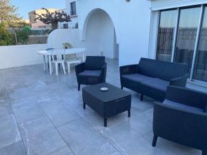 une terrasse avec des canapés, une table, une table et des chaises dans l'établissement La perle de Sète, à Sète