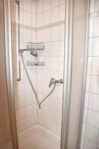 La salle de bains est pourvue d'une douche avec un pommeau de douche. dans l'établissement Pension Bergbauer, à Prackenbach