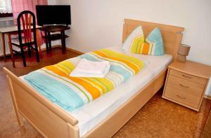 - une chambre avec un lit doté d'une tête de lit en bois et d'une table dans l'établissement Pension Bergbauer, à Prackenbach