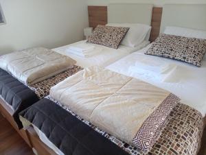 Tres camas sentadas una al lado de la otra en una habitación en Villa Mia Ana, en Međugorje