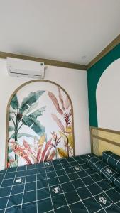 Victoria Homestay في Phường Sáu: سرير في غرفة مع لوحة على الحائط