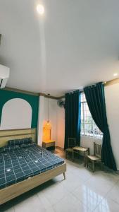 1 dormitorio con 1 cama, 2 sillas y ventana en Victoria Homestay en Phường Sáu