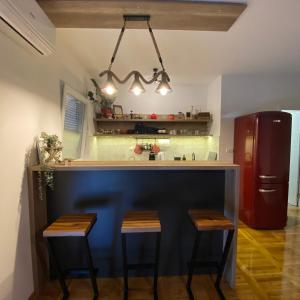 a kitchen with a bar with stools and a refrigerator at The Sailor in Belgrade