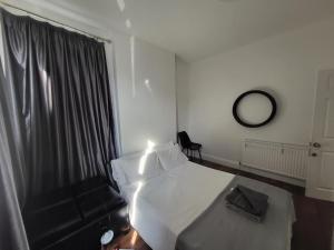 een hotelkamer met een wit bed en een raam bij Remarkable 1-Bed House the entire first floor in Westcliff On Sea