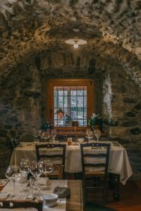 Agriturismo Ferdy في Lenna: غرفة طعام مع طاولات وشخص في نافذة