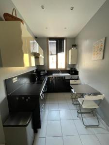 a kitchen with a sink and a table and chairs at Lou pescadou in Saint-Raphaël