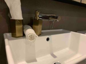 a white sink with a roll of toilet paper on it at Breathtaking sea/city views 1B APT MEL CBD near Crown, DFO, Southern Cross in Melbourne +6 photos