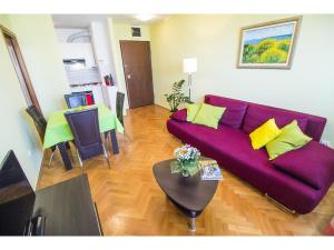 a living room with a purple couch and a table at Apartment Seagull in Split