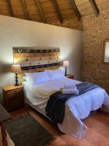 a bedroom with a large bed with a wooden headboard at Soetgeluk Farm Cottage in Hekpoort