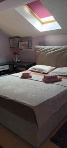 a bedroom with a large bed with two towels on it at Apartman Gaga in Pirot
