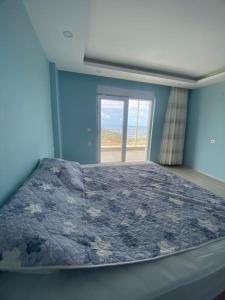um quarto azul com uma cama e uma janela em Villa Venus em Gazipasa