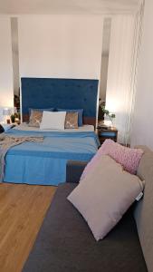 a bedroom with a blue bed and a couch at Best Apartment in the Center in Mukacheve
