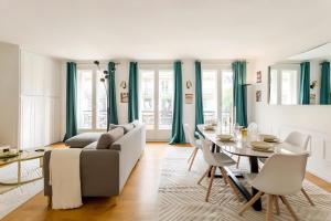 a living room with a couch and a table at Spacious, Central & Historic Getaway - 5 Star Location in Paris