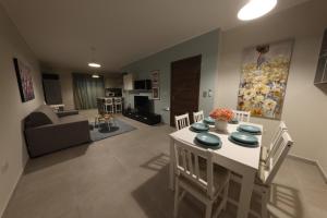 eine Küche und ein Wohnzimmer mit einem Tisch und Stühlen in der Unterkunft Comfort and Convenience flat 4 dad's court in St Paul's Bay