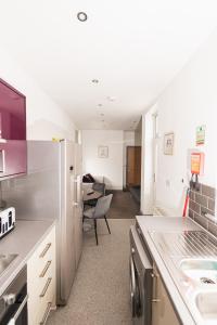 a kitchen with a stainless steel refrigerator and a dining room at Villette - 3 bdrm flat sleeps 5 great place for contractors in Sunderland