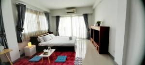 CHIANG MAI Home في شيانغ ماي: غرفة نوم صغيرة مع سرير وطاولة