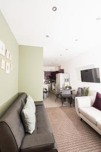ein Wohnzimmer mit einem Sofa und einer Küche in der Unterkunft Villette - 3 bdrm flat sleeps 5 great place for contractors in Sunderland