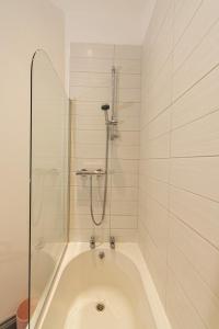 een badkamer met een bad en een douche bij Villette - 3 bdrm flat sleeps 5 great place for contractors in Sunderland